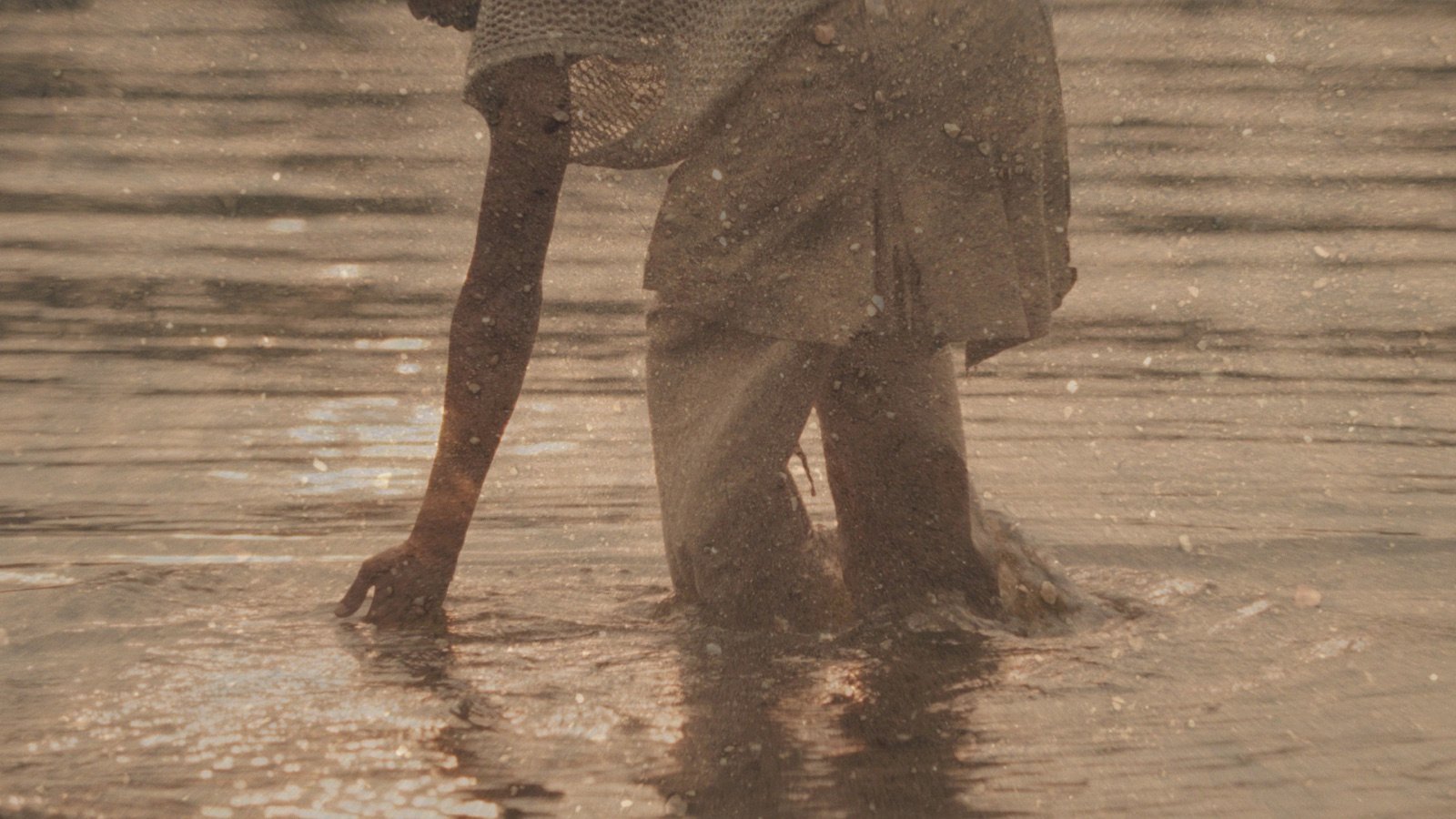 Manzi Mbaya marchant dans l'eau peu profonde, image tirée du film KUBANA