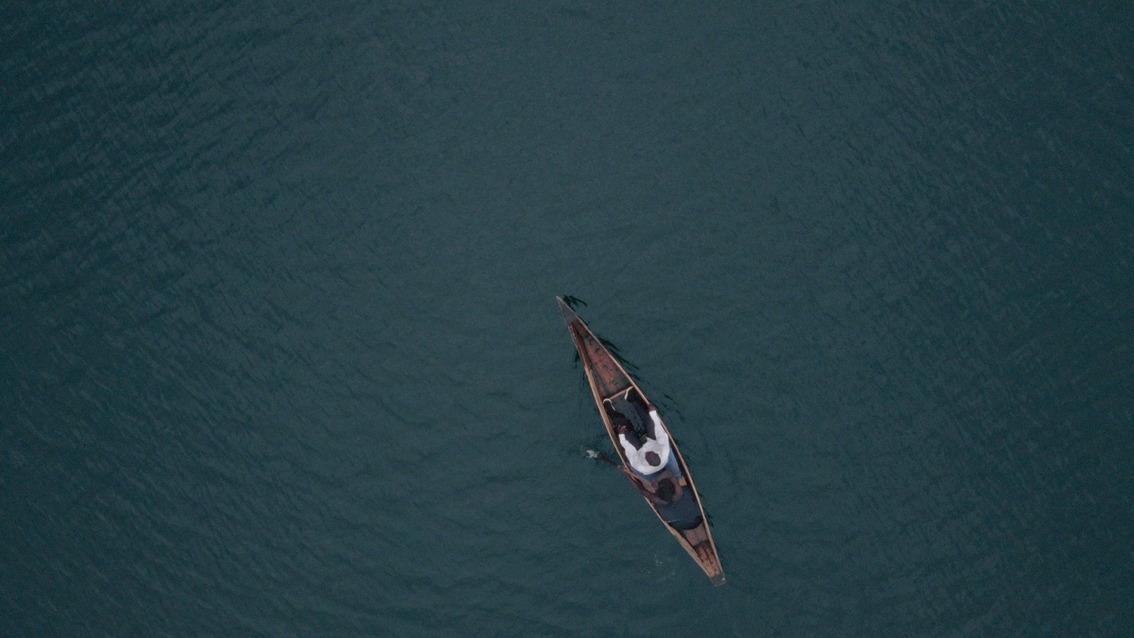 Elias Jean Nsanzintwari en pirogue, vue aérienne du lac, image tirée du film KUBANA